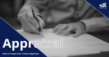 Black and white picture of a person's hands signing documents with a fountain pen