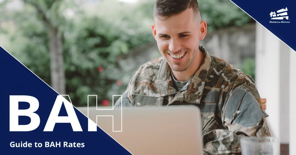 man in military camo smiling while looking at his computer