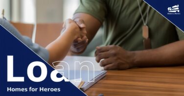 Man Wearing Dog Tags Shaking Hands Across a Table with a Woman with Papers On It