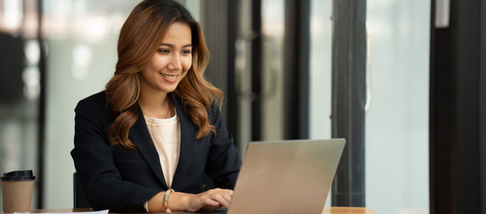 young female professional on laptop in office learning Canva for real estate agents