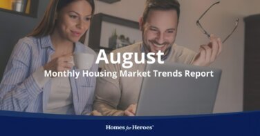 man woman couple at table looking at laptop researching housing market trends August report Homes for Heroes