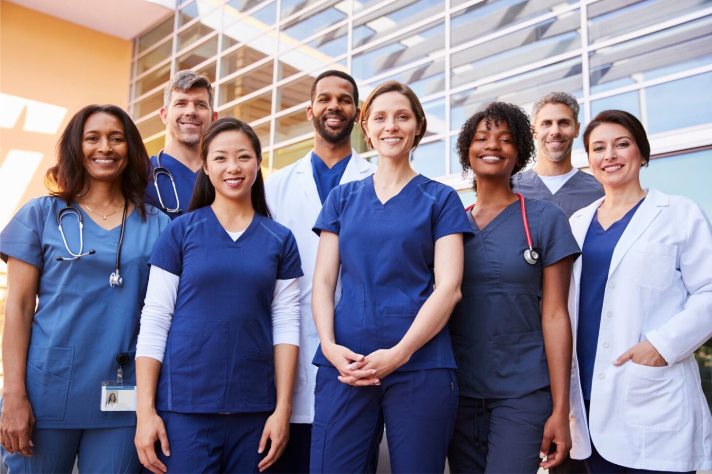 Medical and healthcare professionals in scrubs and white coats inside hospital  