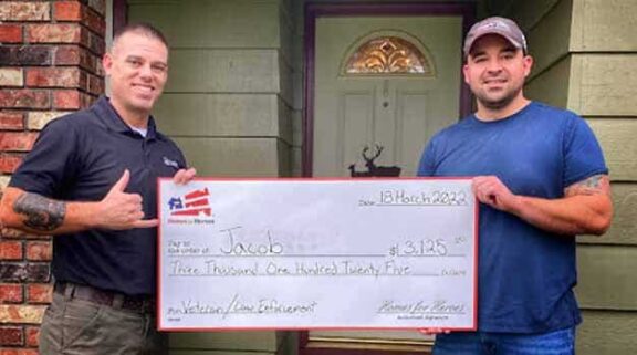 Verteran law enforcement hero Jacob holding a big check