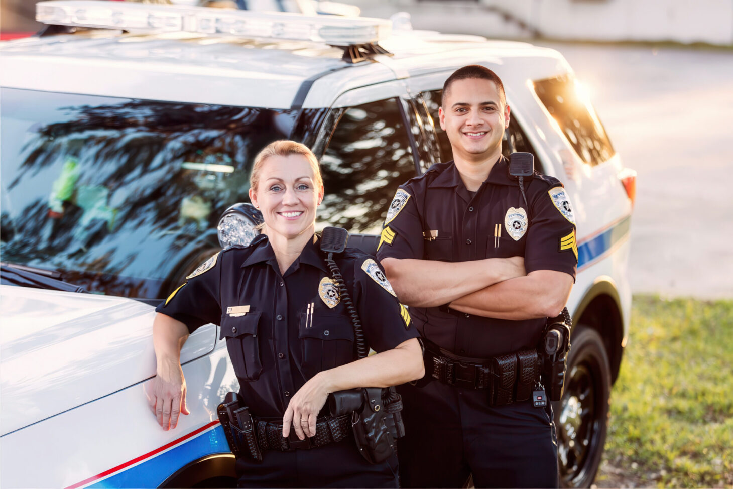 Uniformed law enforcement heroes smiling outside police SUV