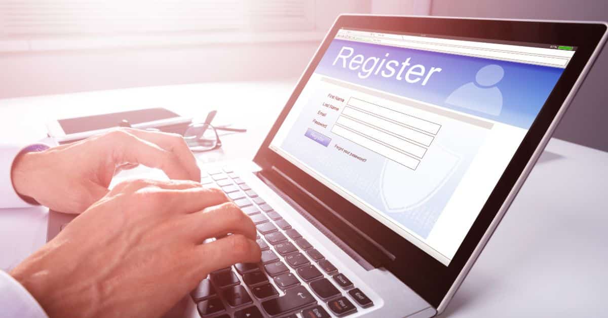 person sitting at desk on laptop filling out lead magnet register form to work with real estate agent