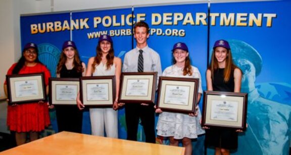 Burbank police award recipients lined up holding their framed awards recognition