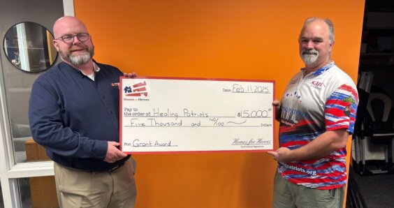 Healing Patriots 5000 grant big check presentation held by two men Homes for Heroes Foundation